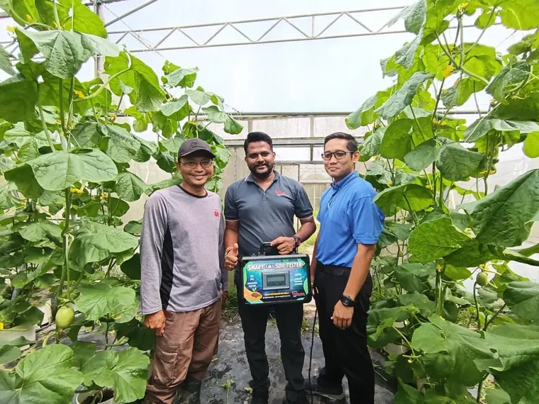 The team with a Smart 7-in-1 Soil Tester in a greenhouse